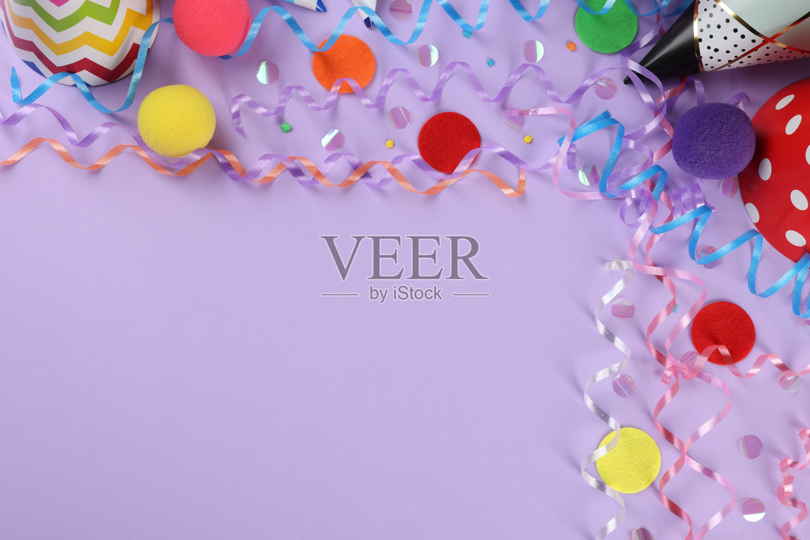 平面铺设构图与彩色蛇形流线和彩色纸屑在紫罗兰色背景，空间为文字照片摄影图片