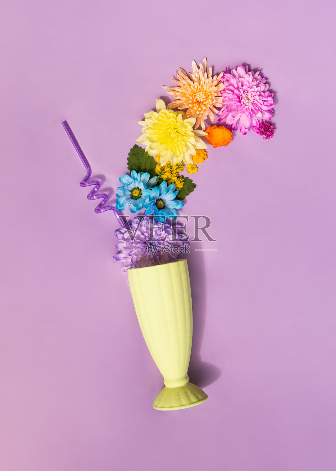 彩色的花朵和甜点杯在柔和的紫色背景。创意食物概念。极简的饮料成分。照片摄影图片