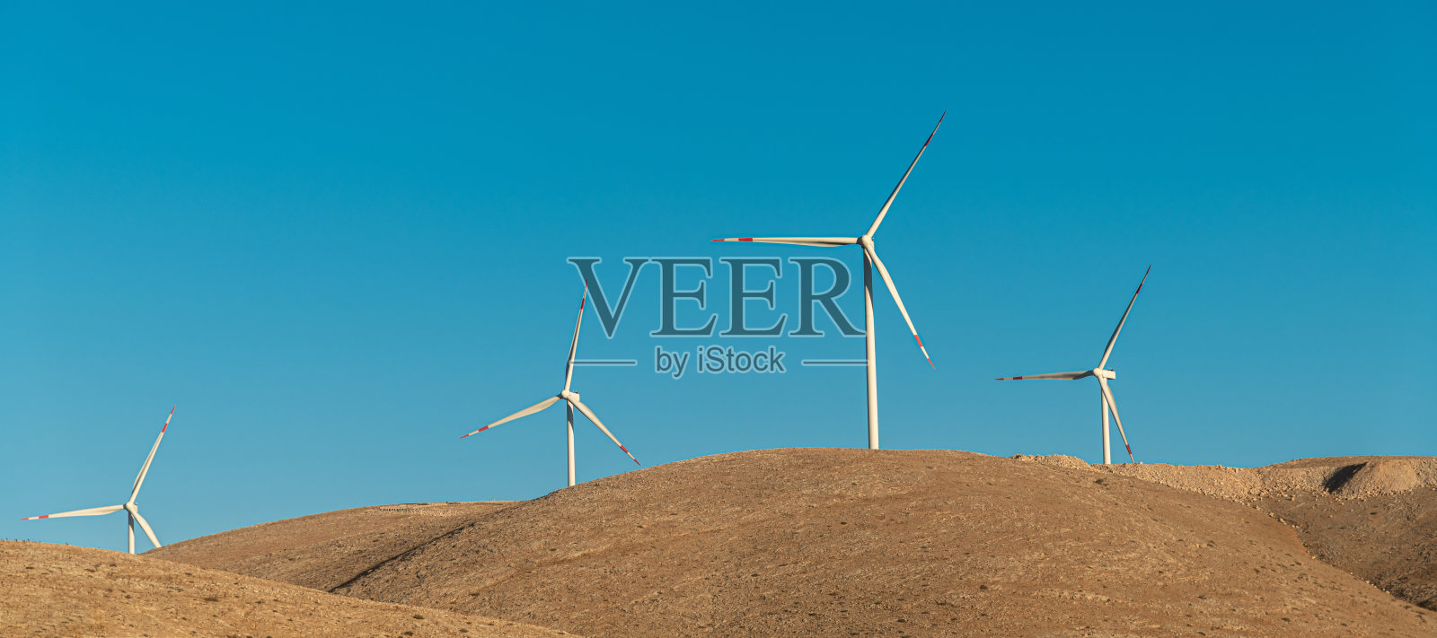 多个风力涡轮机在日出时竖立在山上发电照片摄影图片