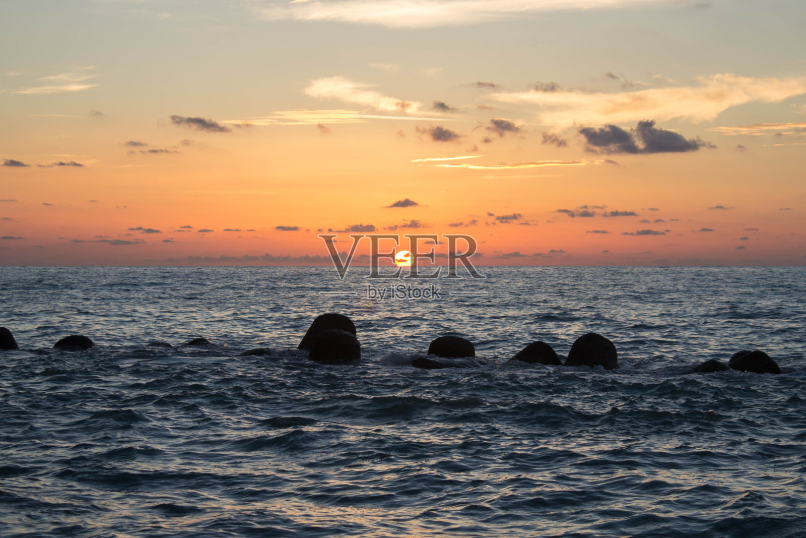 美丽的一天，平静的海面上的日落照片摄影图片