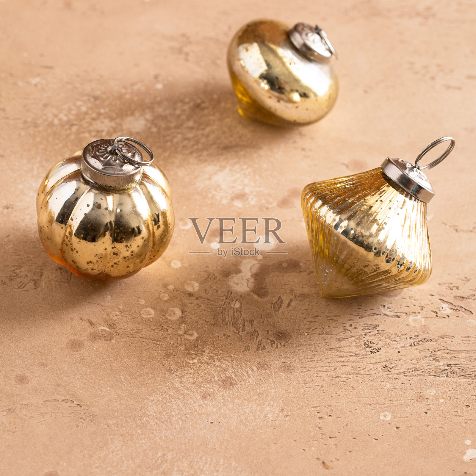 三个金色圣诞球米色背景为冬季节日的概念。副本的空间。照片摄影图片