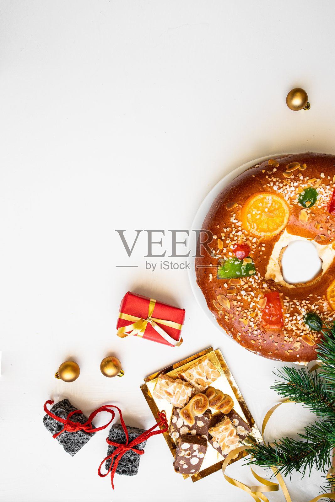 西班牙圣诞节的概念。罗斯康·德·雷耶斯，西班牙蛋糕，甜煤，蛋卷和白色背景的红色礼品盒照片摄影图片