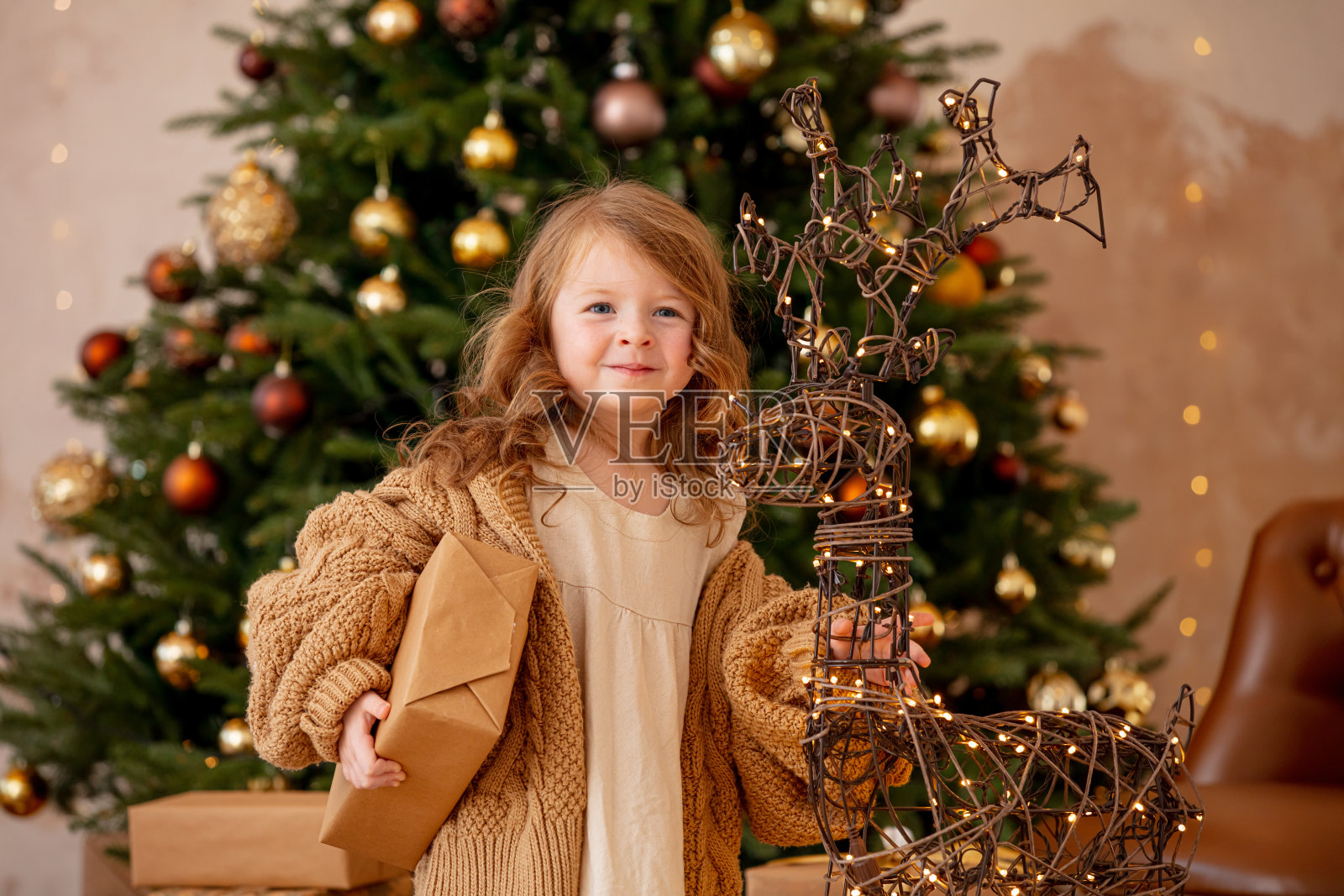 可爱，美丽的小女孩在圣诞装饰圣诞树的背景。照片摄影图片