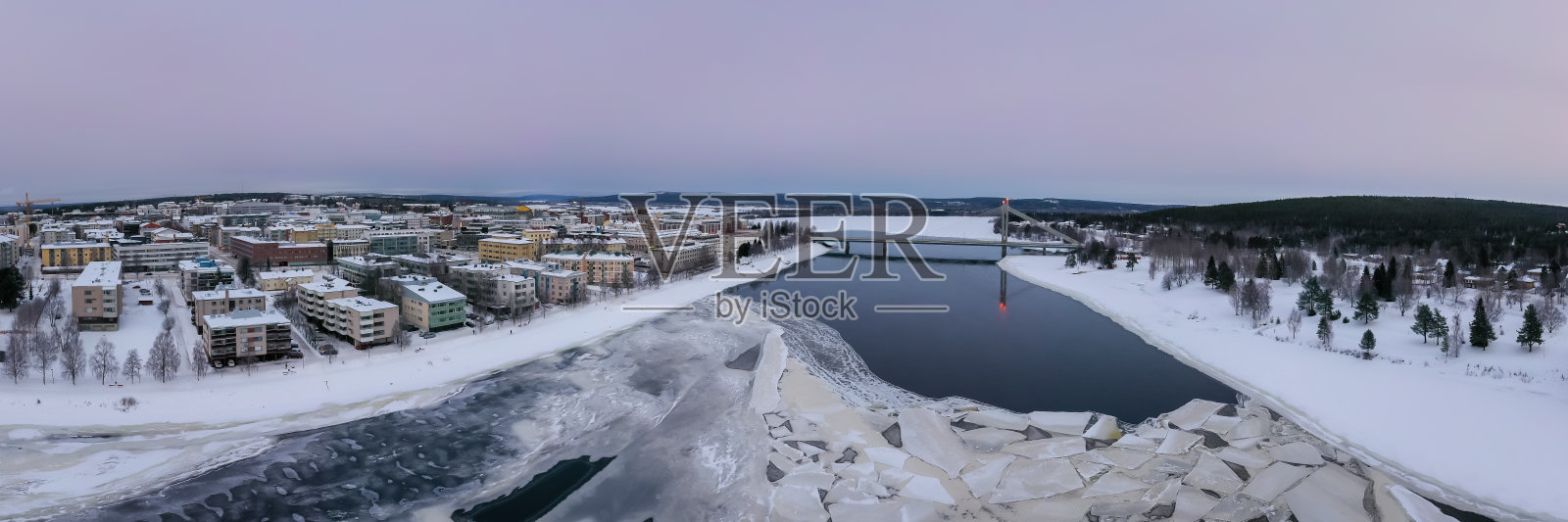 芬兰罗瓦涅米，美丽的冬季景观，建筑和乌纳斯约基河上的一座桥照片摄影图片