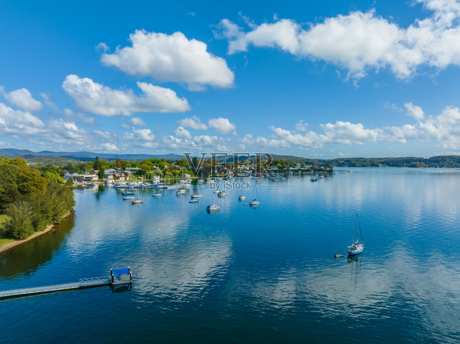 早晨的海滨景色与云，船和蓝色的湖水。照片摄影图片