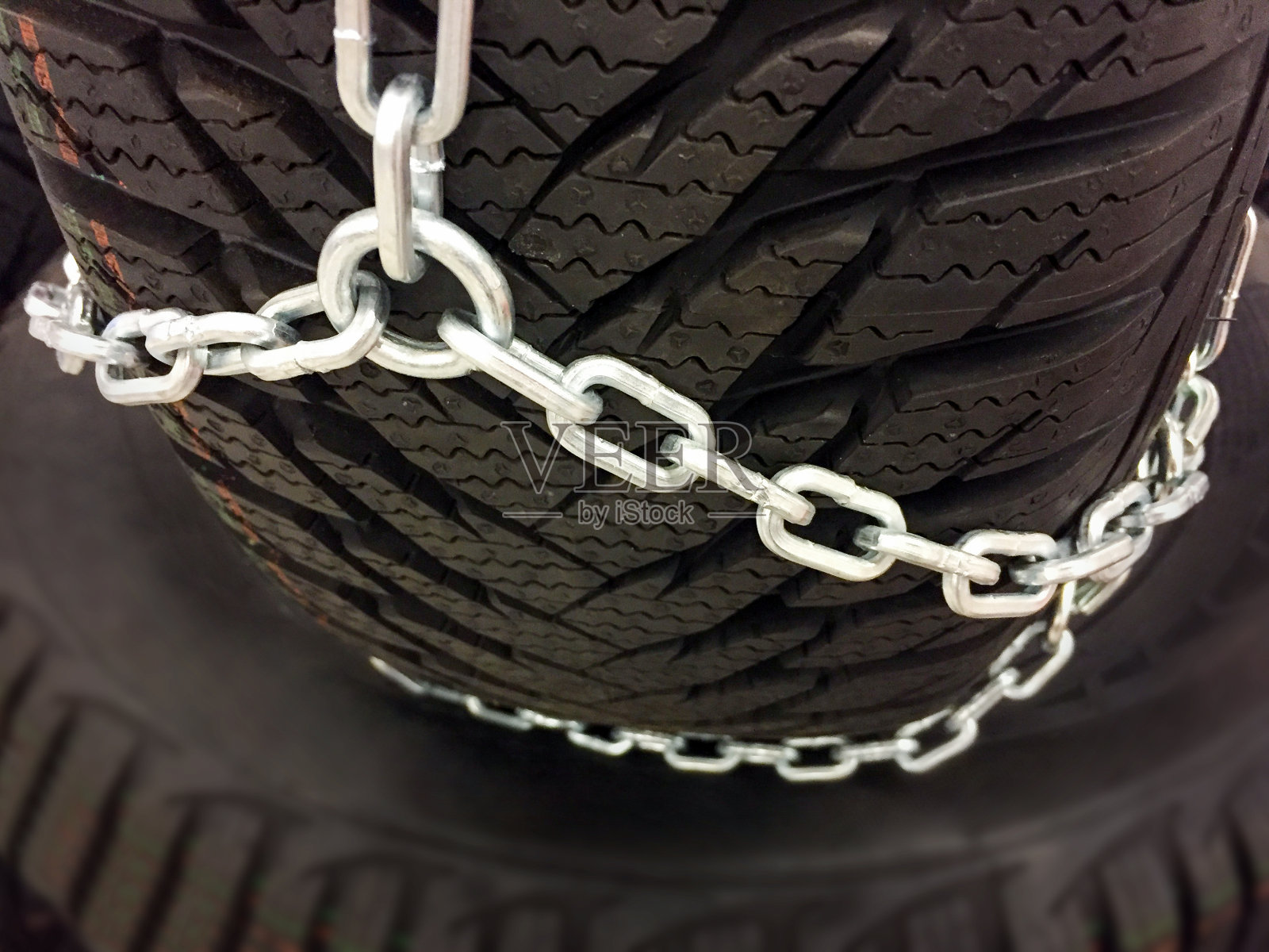 汽车车轮与冬季轮胎和雪链。轮胎防滑链照片摄影图片