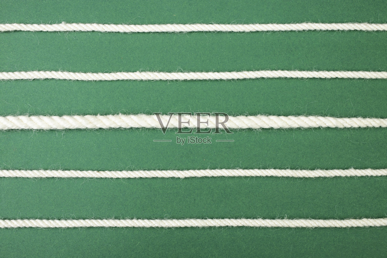 绿色背景上的白色棉绳线照片摄影图片