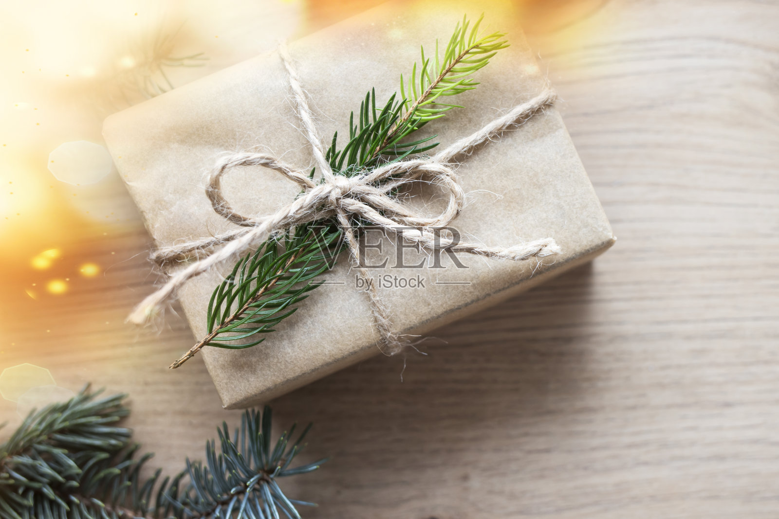 圣诞礼物在牛皮纸与天然云杉枝在木制背景。俯视图，文本空间。照片摄影图片