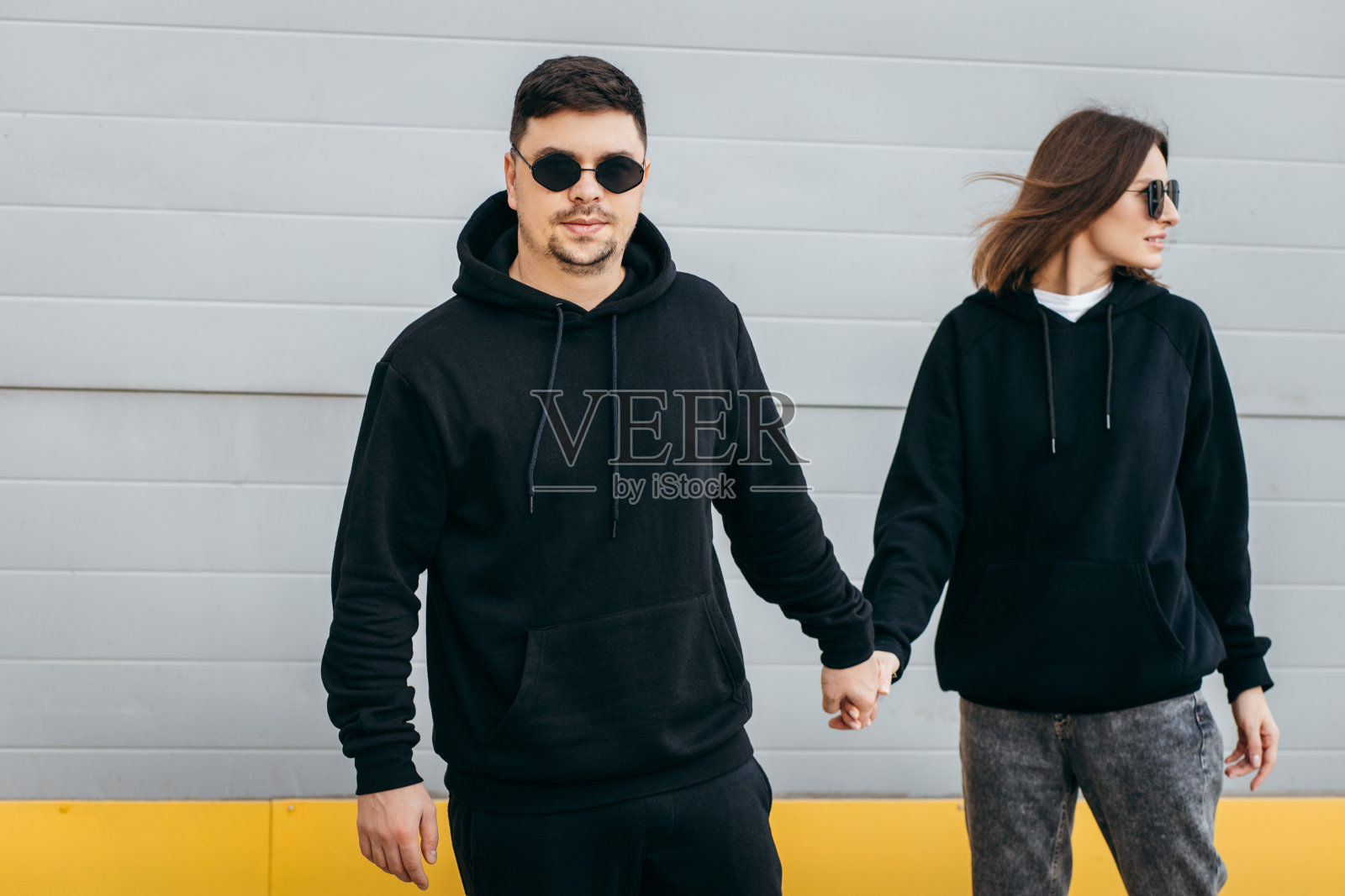 年轻的男男女女，戴着眼镜，穿着黑色卫衣照片摄影图片