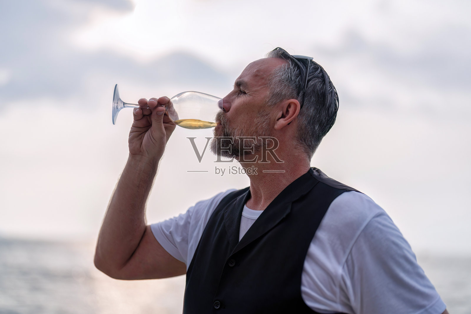 商务旅行者在假日站在游艇甲板上自由饮酒放松照片摄影图片