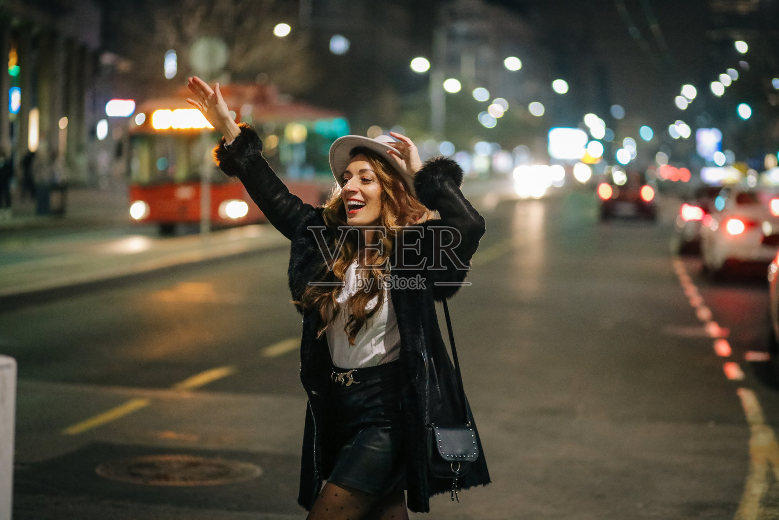 一名妇女站在城市的路上叫出租车照片摄影图片