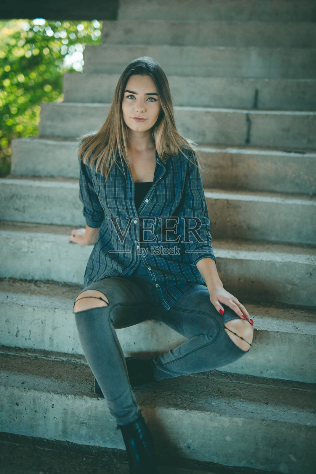 迷人的波斯尼亚高加索妇女坐在一座废弃建筑的楼梯上照片摄影图片