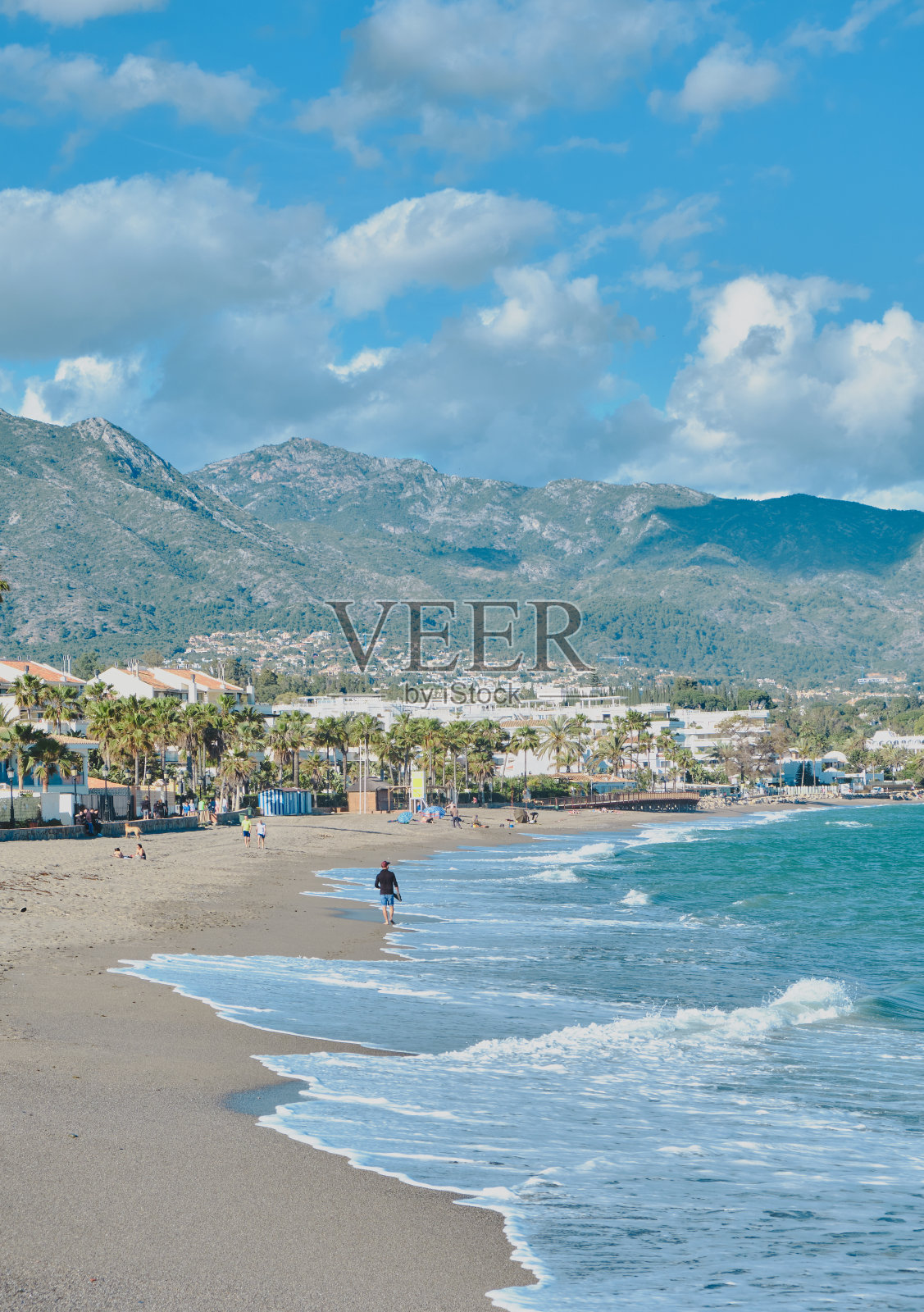 西班牙马贝拉沙滩上的人们的垂直镜头照片摄影图片