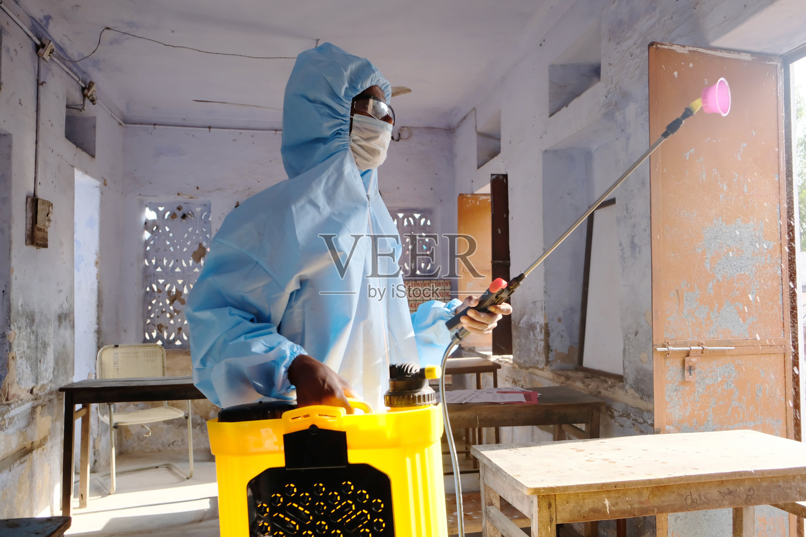新冠肺炎期间，穿着防护服的印度卫生工作者正在一所学校进行消毒照片摄影图片