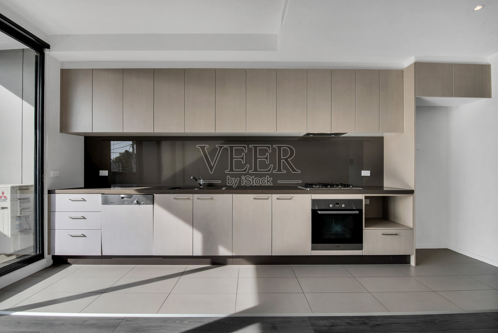 厨房配有米色木制家具和灰色强化地板照片摄影图片