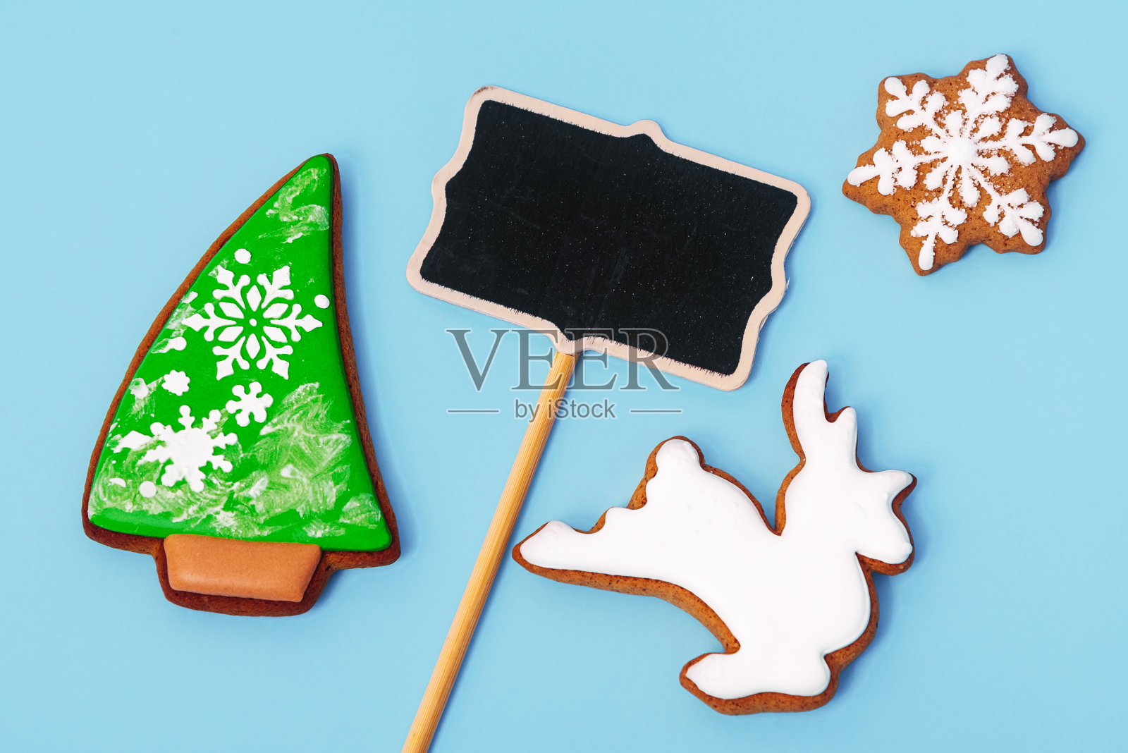 平面构图与美味的自制圣诞饼干和空间祝贺文字的蓝色背景，俯视图。特写镜头。新年快乐和圣诞快乐的概念照片摄影图片