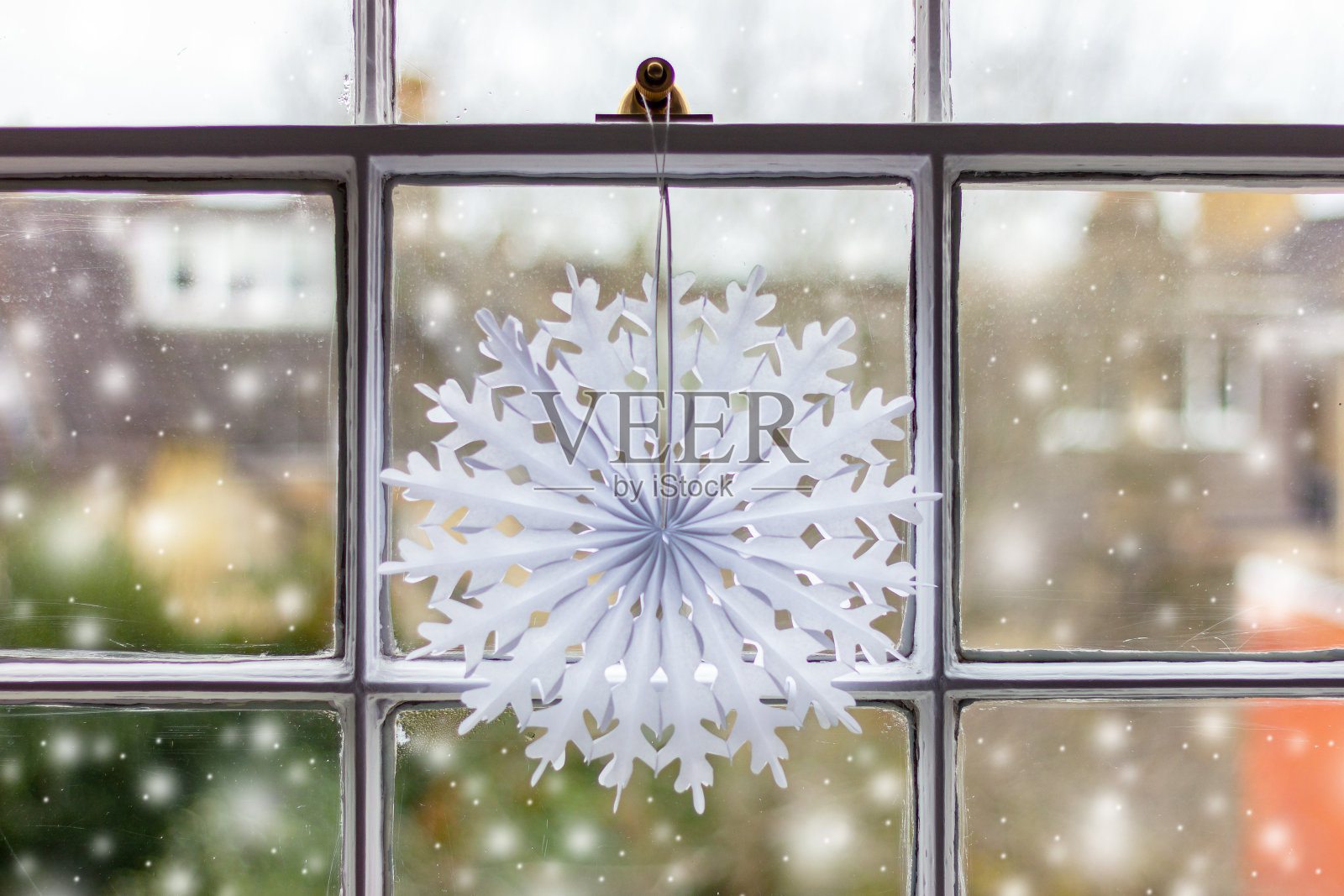 窗户上有一片纸雪花。冬天，新年和圣诞节的装饰照片摄影图片
