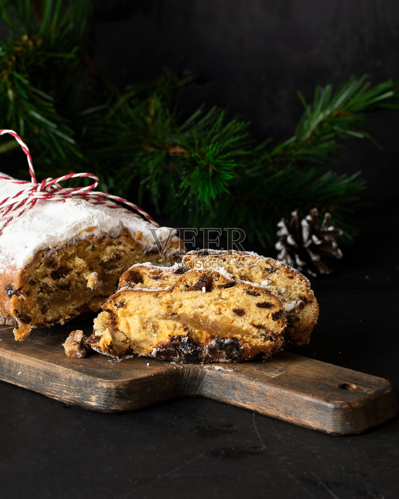 圣诞装饰的砧板上被偷走了。德国水果面包，含有坚果、香料、干果和涂有糖粉的杏仁糖照片摄影图片