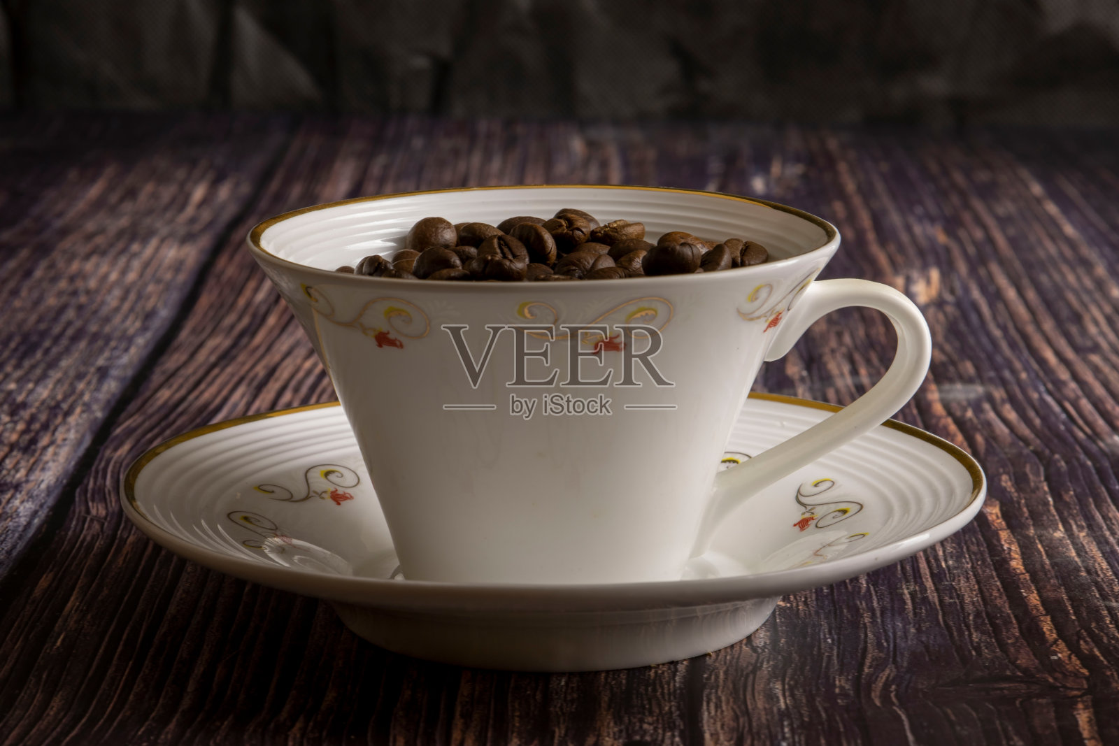 深色背景上有咖啡豆的杯子。照片摄影图片