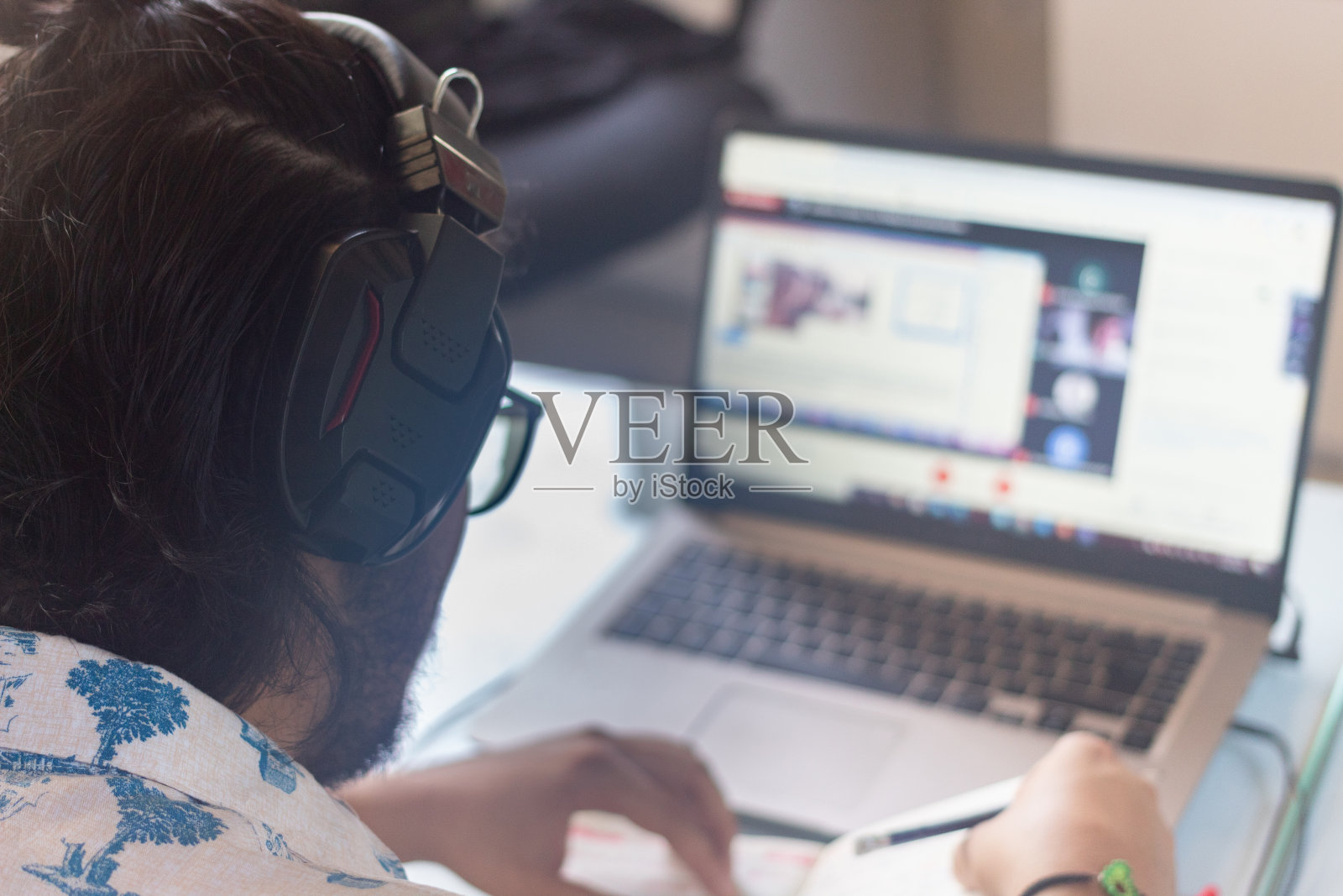 一个带着耳机的西班牙人在家专注于他的在线课程照片摄影图片