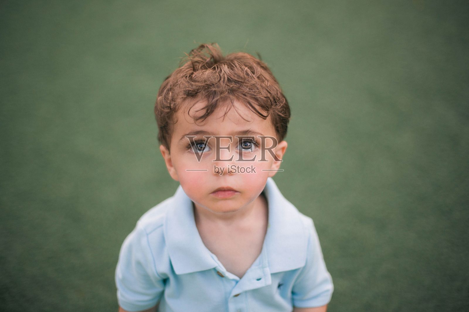 一个美丽的白人小男孩的特写与可爱的面部表情向前看照片摄影图片