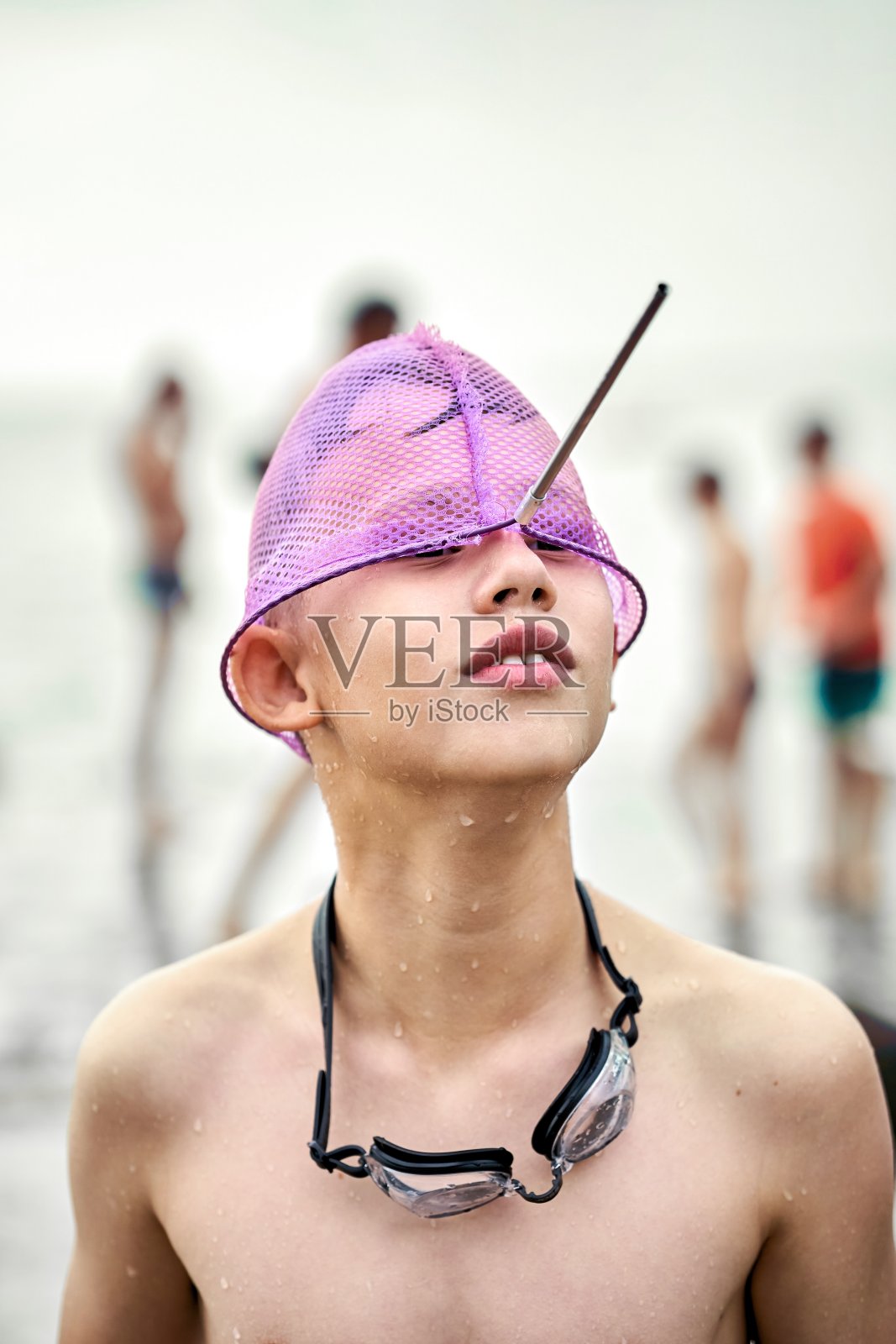 少年在登陆网对着模糊的海岸做鬼脸照片摄影图片