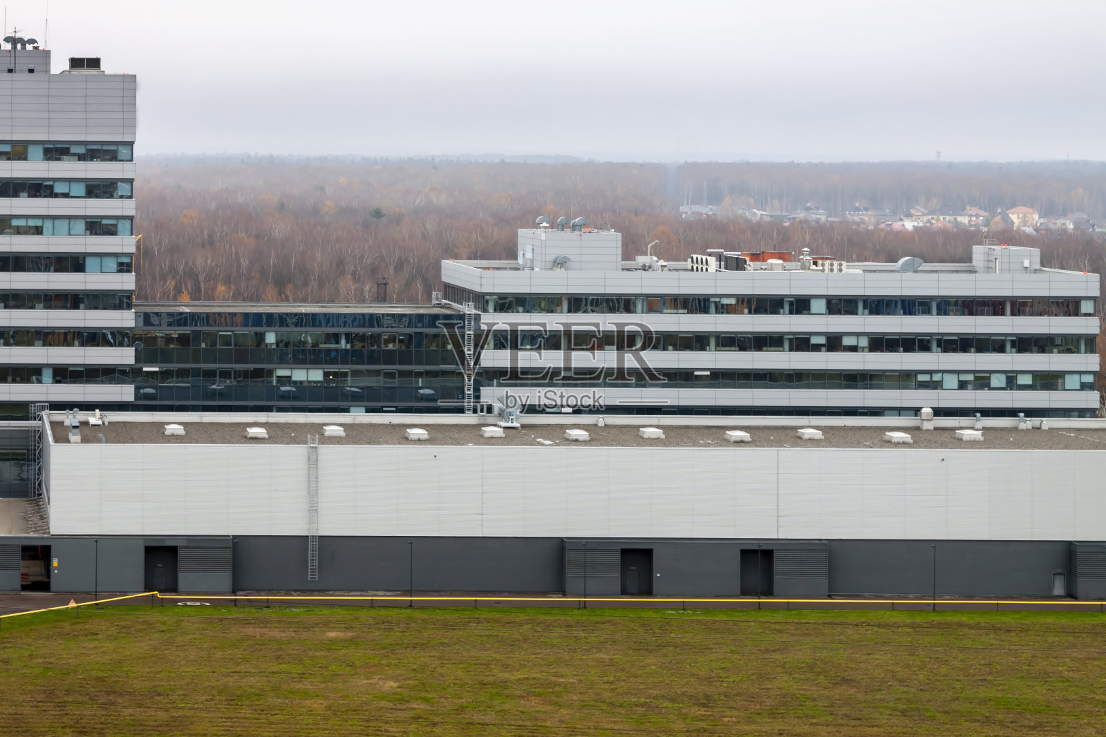 新建现代化灰色办公仓库大楼。阴天的秋天或春天背景。照片摄影图片