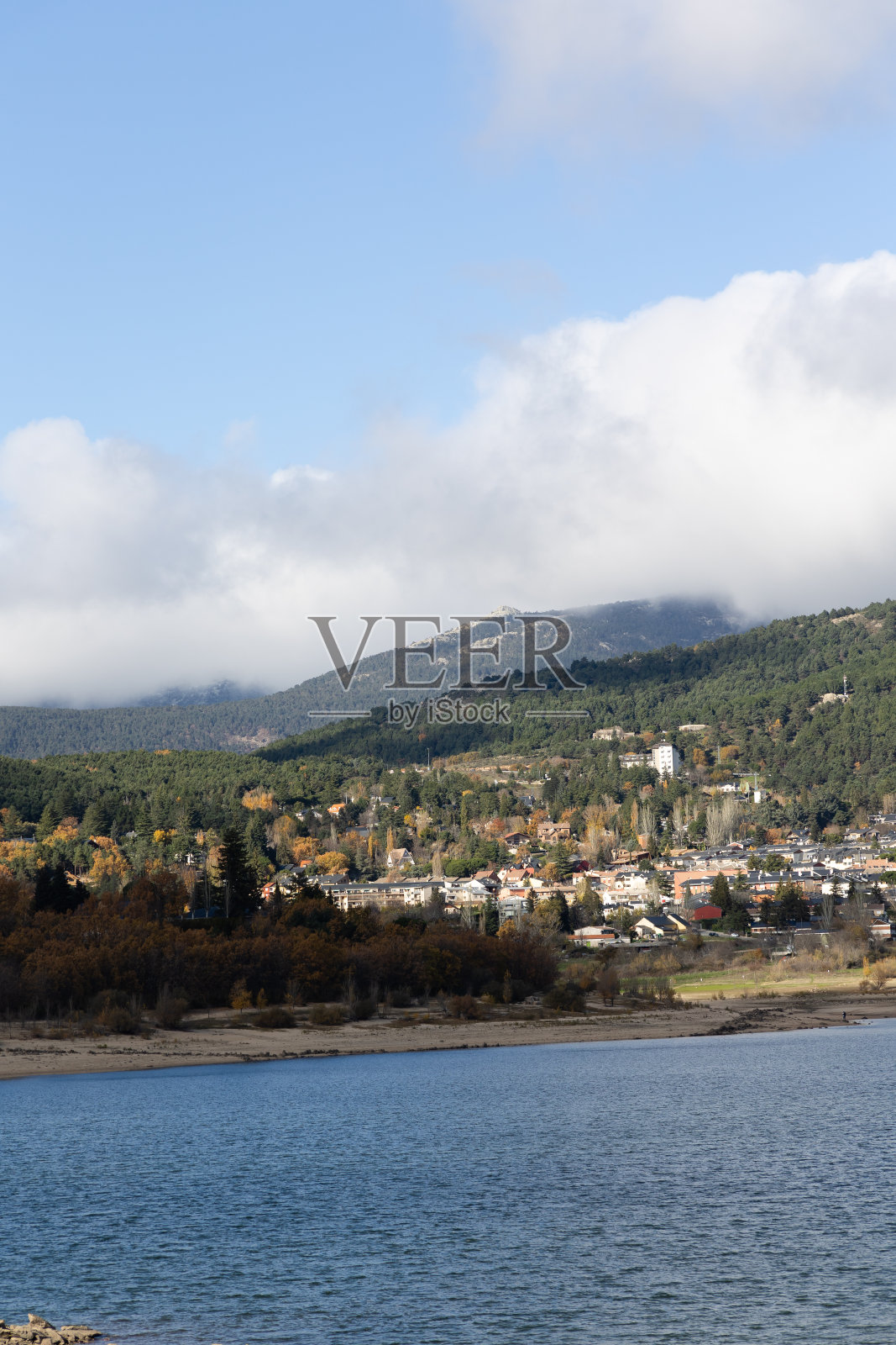 秋天的纳瓦塞拉达水库，背景是小镇和马德里瓜德拉拉马山脉照片摄影图片