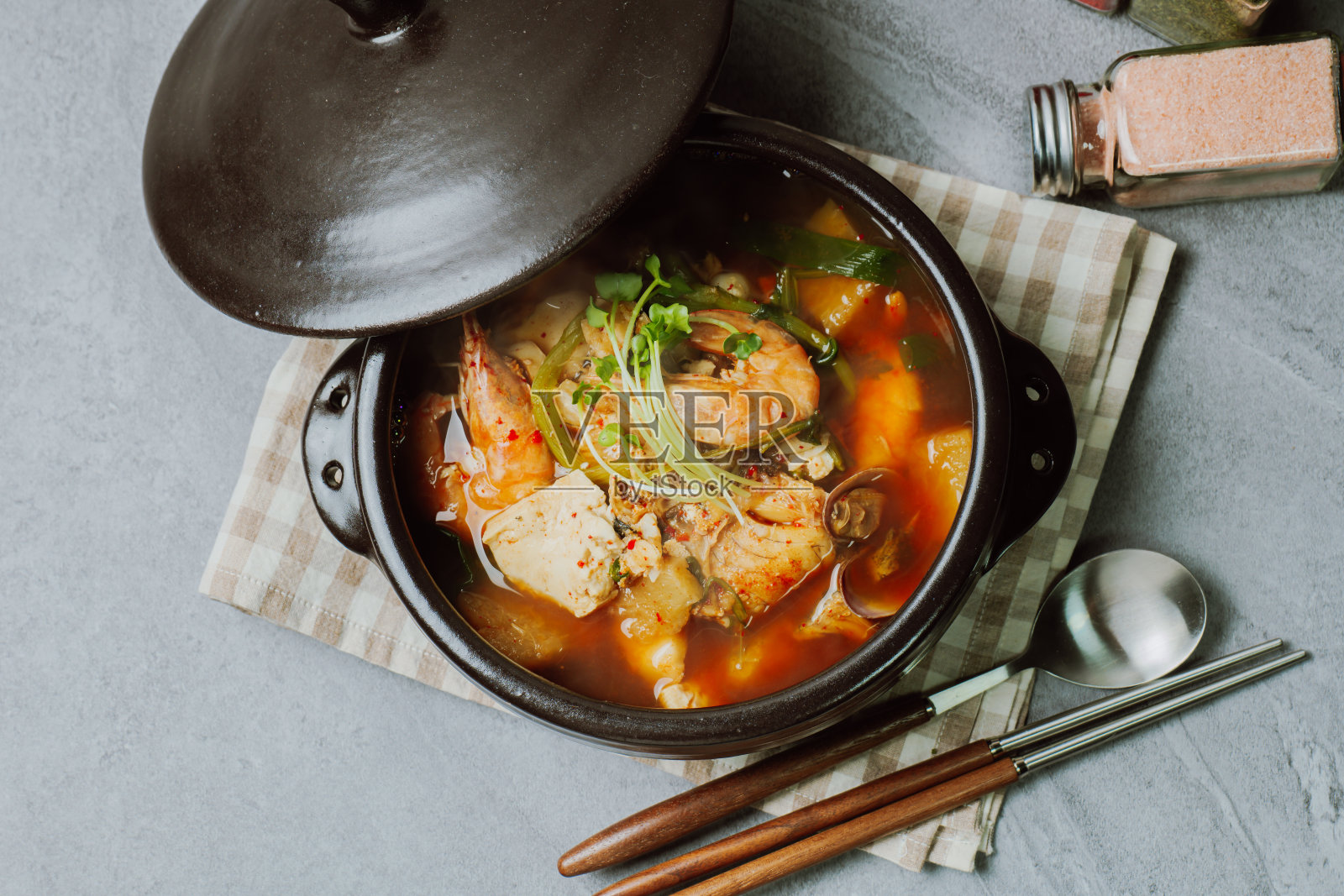 鲜明太鱼汤用鲜明太鱼、豆腐、萝卜、雏菊等蔬菜制成，用红辣椒粉调味。照片摄影图片