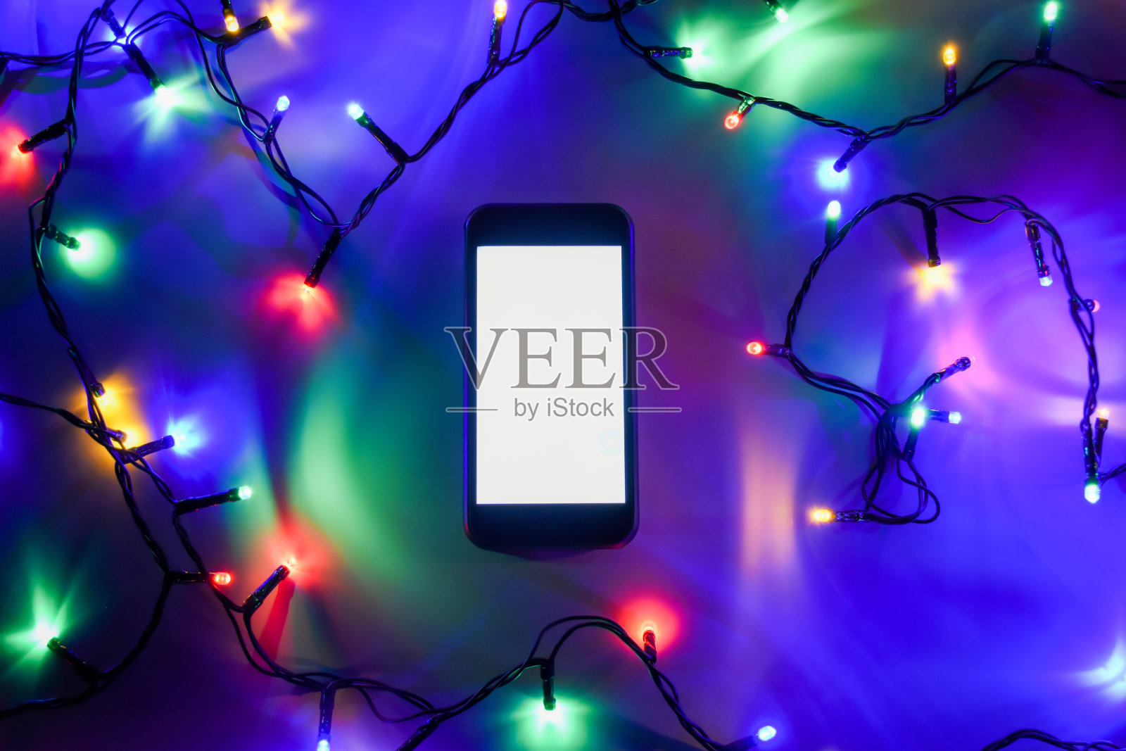 配有圣诞彩灯的智能手机照片摄影图片