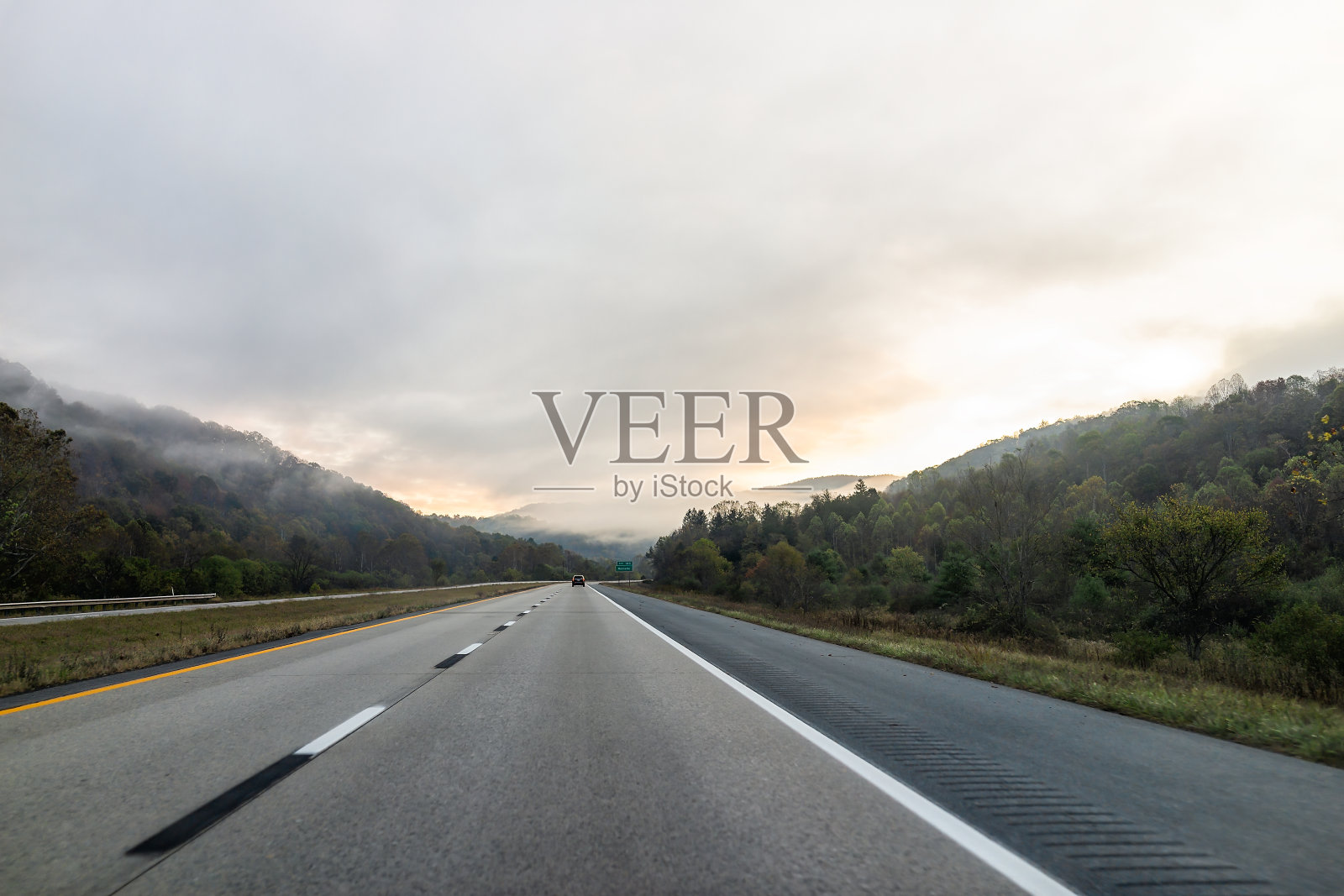 雾霾天气早晨日出在公路64号高速公路行驶在西弗吉尼亚州的乡村与车辆在交通和标志出口Rainelle照片摄影图片