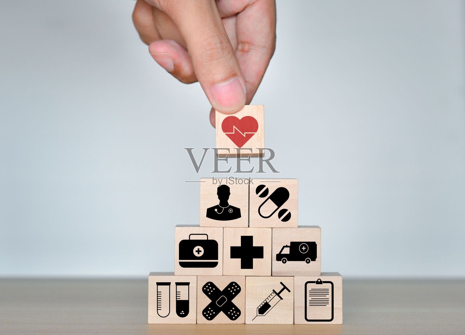 男人的手拿木立方体堆叠图标保健医疗蓝色背景照片摄影图片