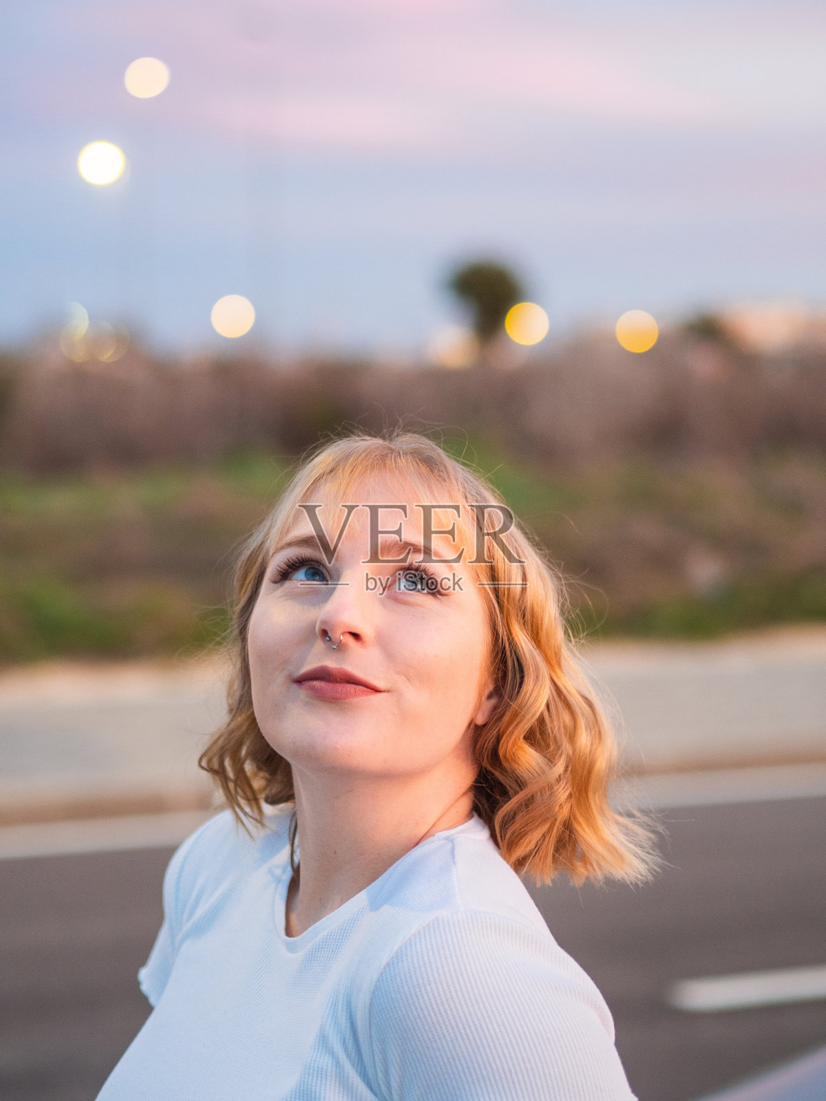 一个来自西班牙的金发白人女人站在路上抬头看照片摄影图片
