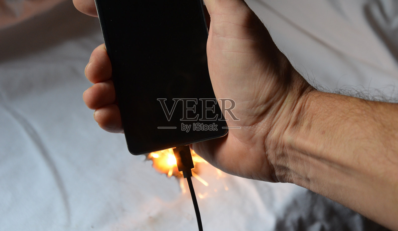 手机电池故障。智能手机可以迅速起火，点燃房屋、公寓或汽车。设备用户有烧伤风险。火焰包围了整个平板电脑照片摄影图片