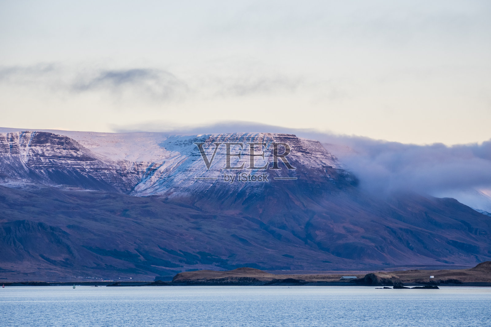 在初冬的黄昏时分，雷克雅未克海湾的山脉被积雪覆盖照片摄影图片