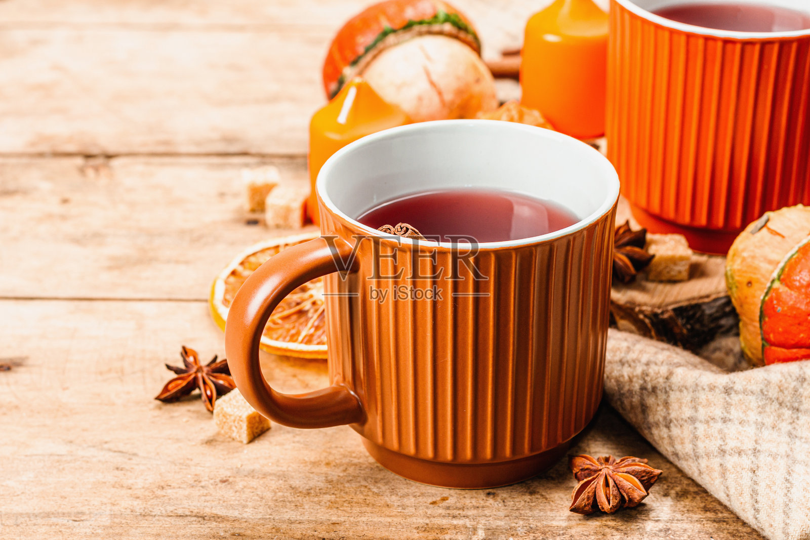 辛辣的热茶。秋好心情，传统秋饮杯。南瓜，围巾，蜡烛照片摄影图片