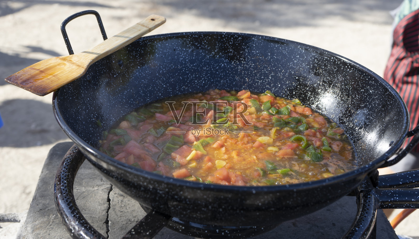 用煎锅煎西红柿、洋葱和甜椒的人照片摄影图片