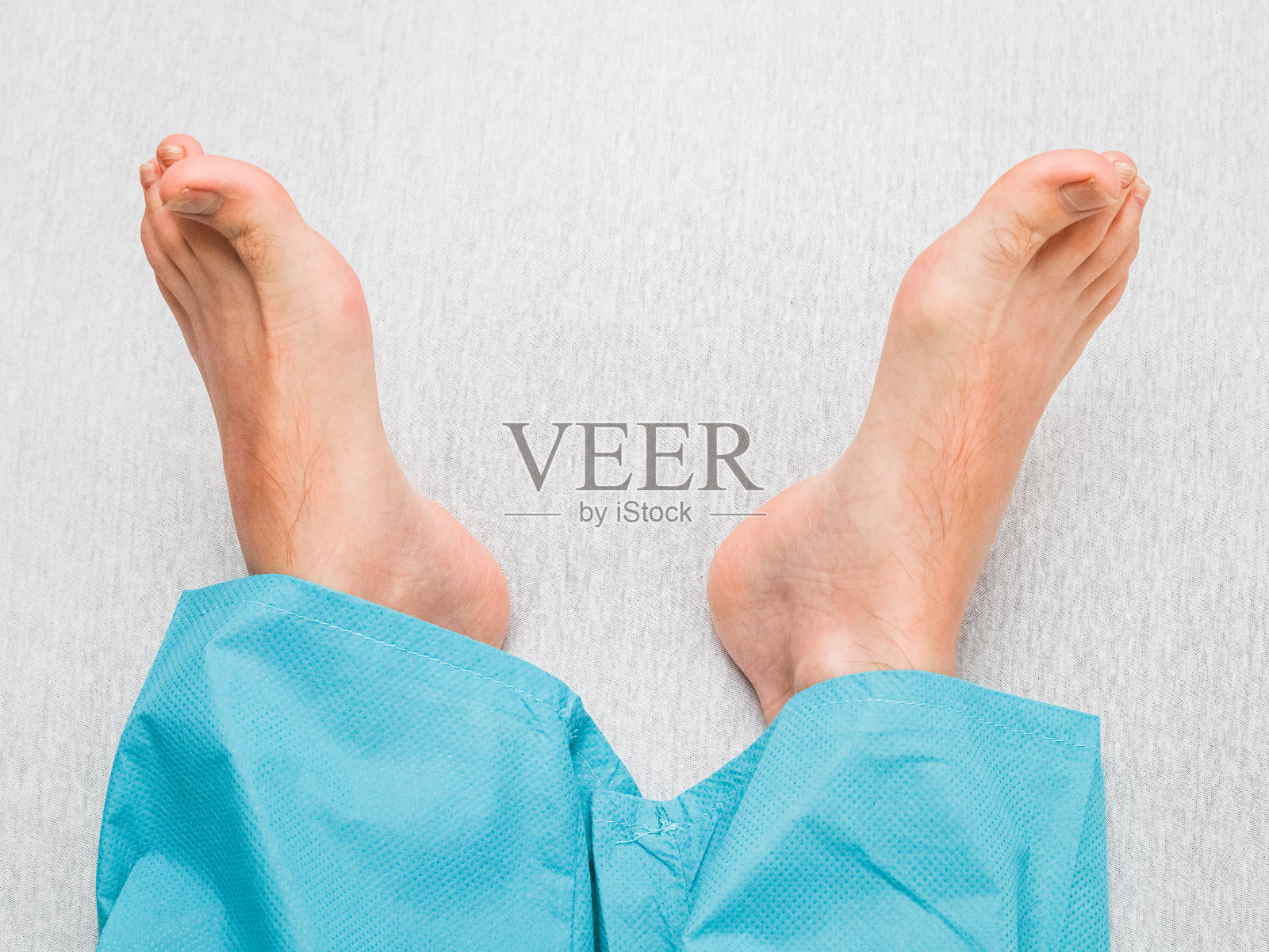 一个年轻的白人男性病人的干净和八字形的脚躺在床上照片摄影图片