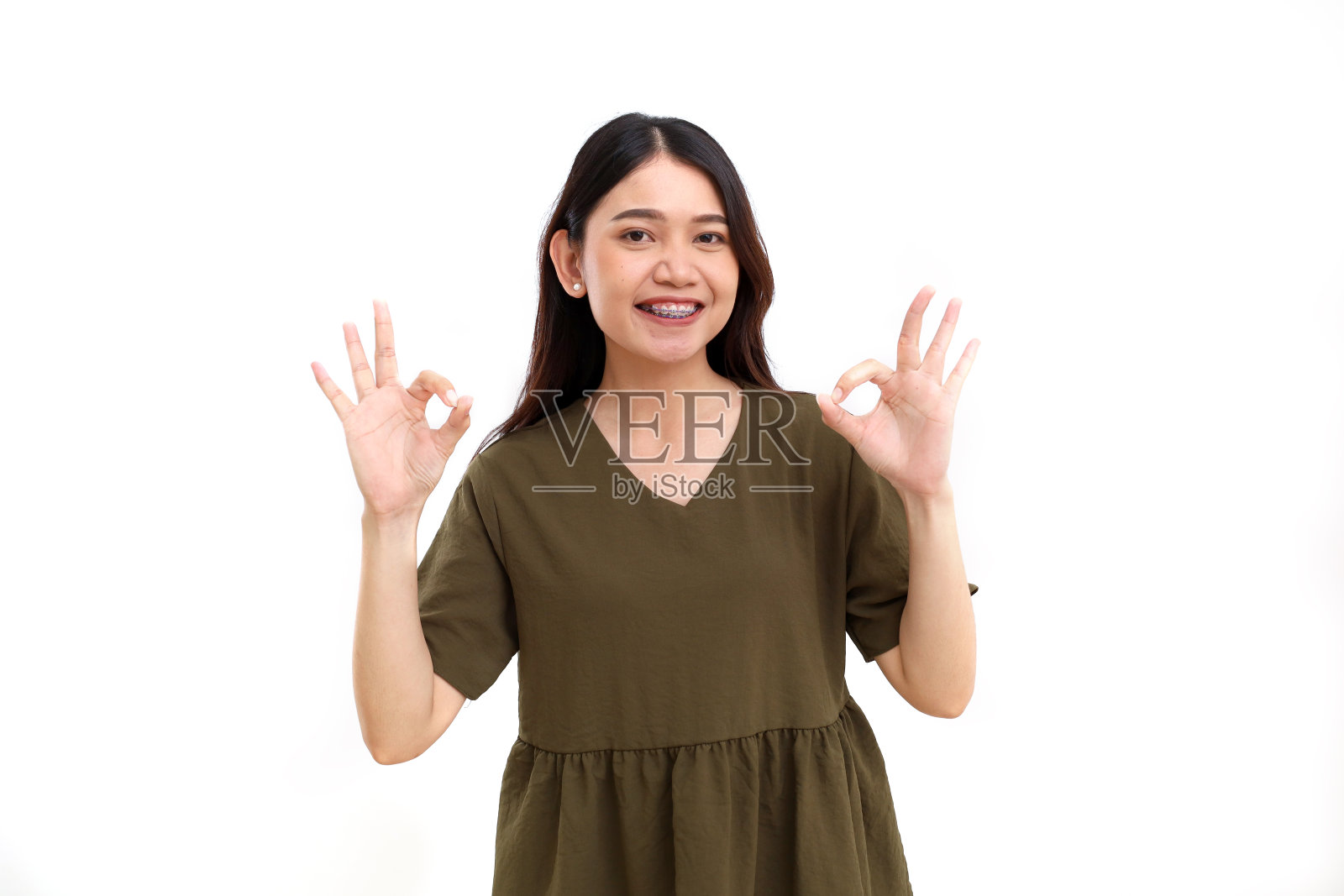 美丽的年轻亚洲妇女的肖像站着，同时展示了好的手势。孤立在白色背景中照片摄影图片