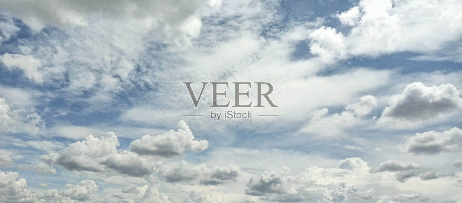 美丽的白云在明亮的蓝天上。晴朗冬天的天空。照片摄影图片