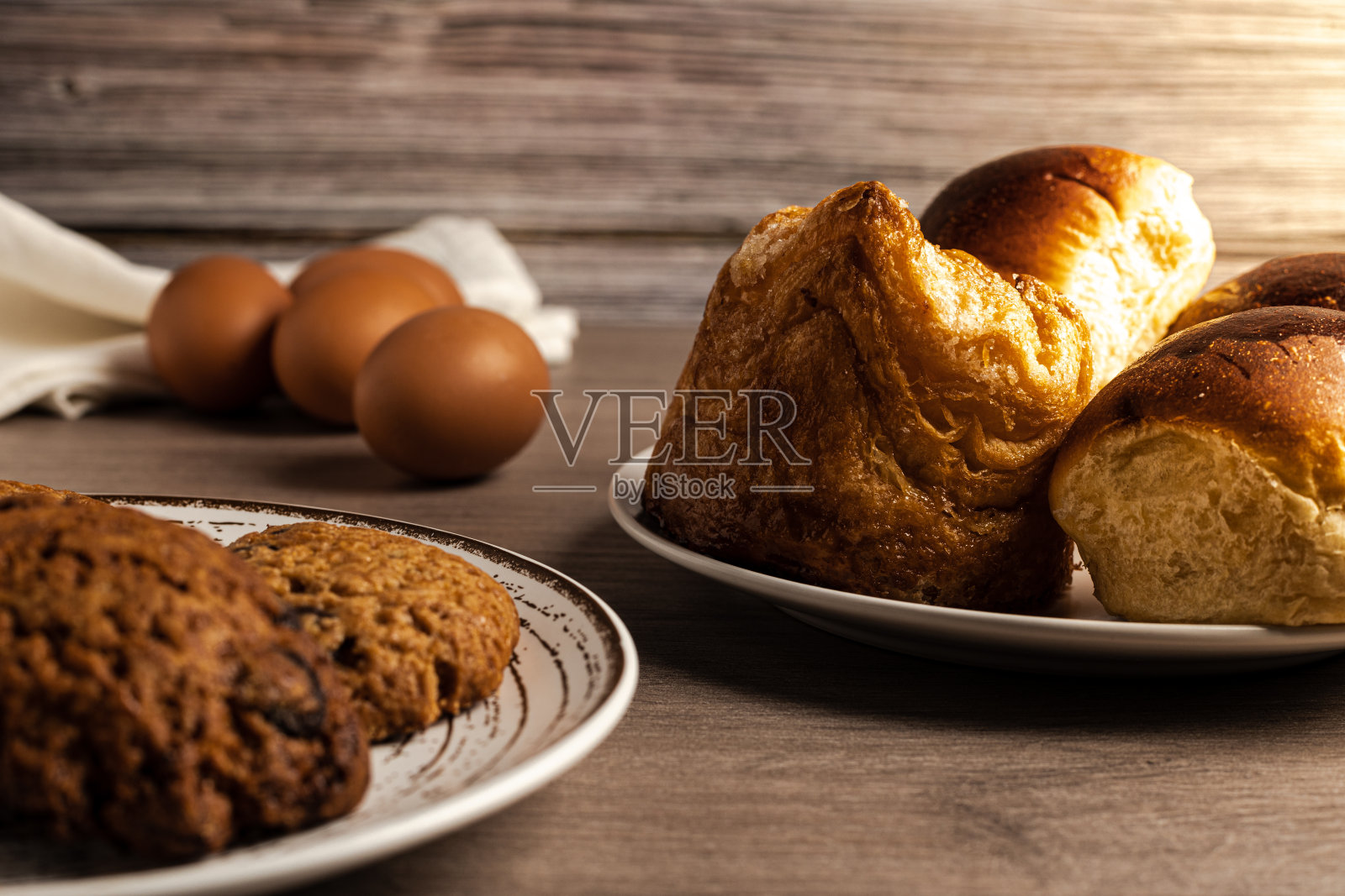 水平照片的鸡蛋，糕点，奶油蛋卷，饼干在木桌和木制背景侧照明照片摄影图片