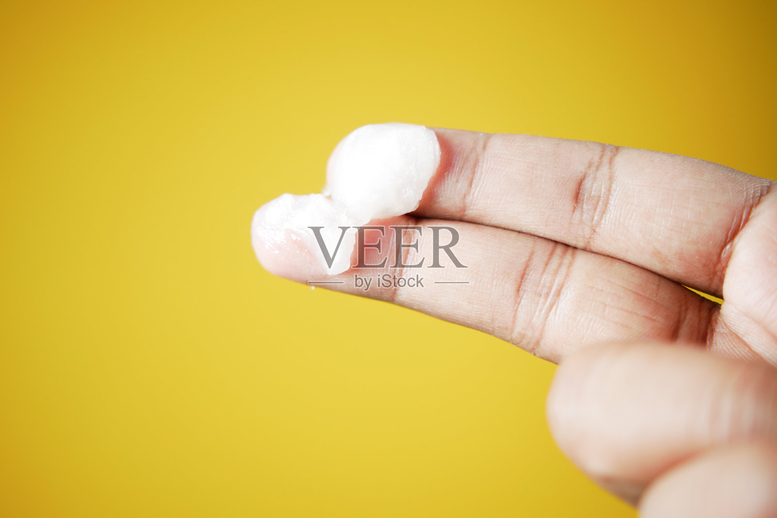 特写男子的手使用凡士林在黄色背景照片摄影图片