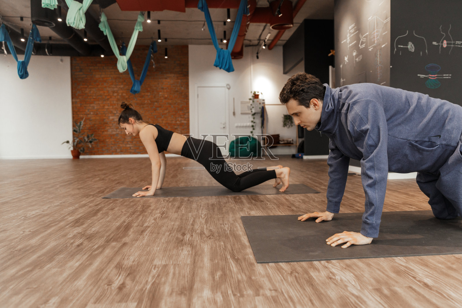 一群年轻人和教练在瑜伽宽敞的工作室练习瑜伽照片摄影图片