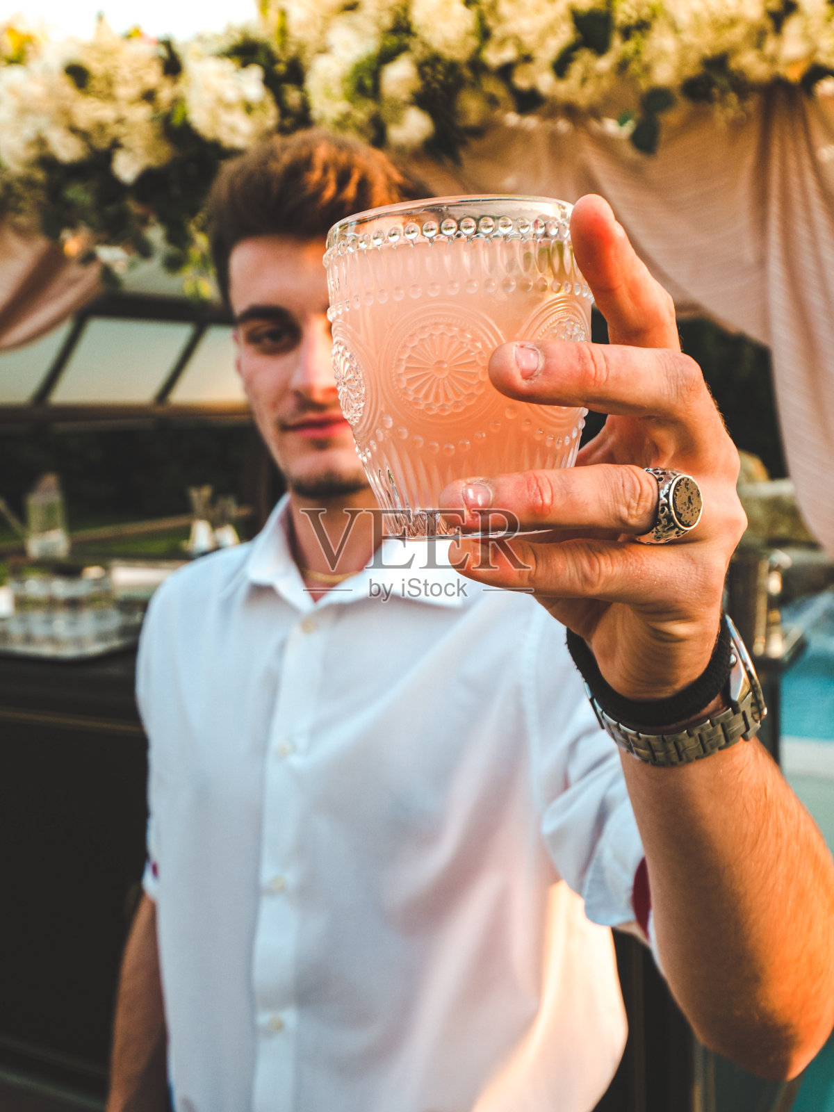一个白人调酒师在一个豪华泳池派对上调制鸡尾酒的垂直镜头照片摄影图片