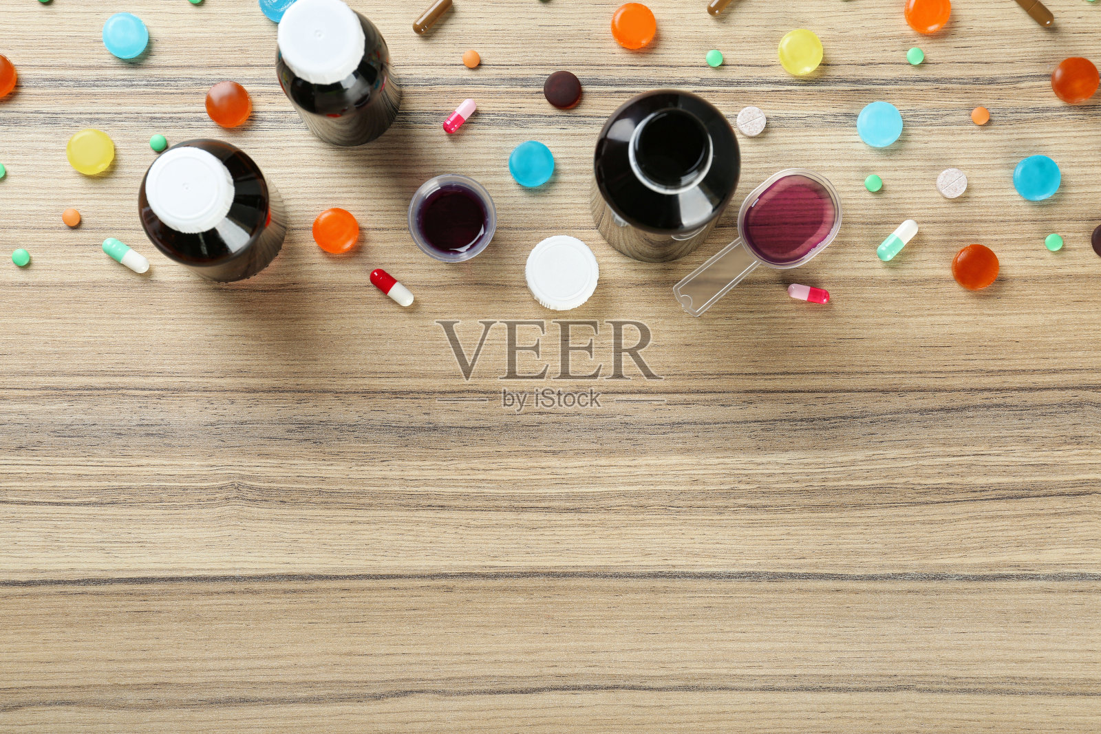 平铺构图与咳嗽药水，糖浆和药片在木制背景。文本空间照片摄影图片