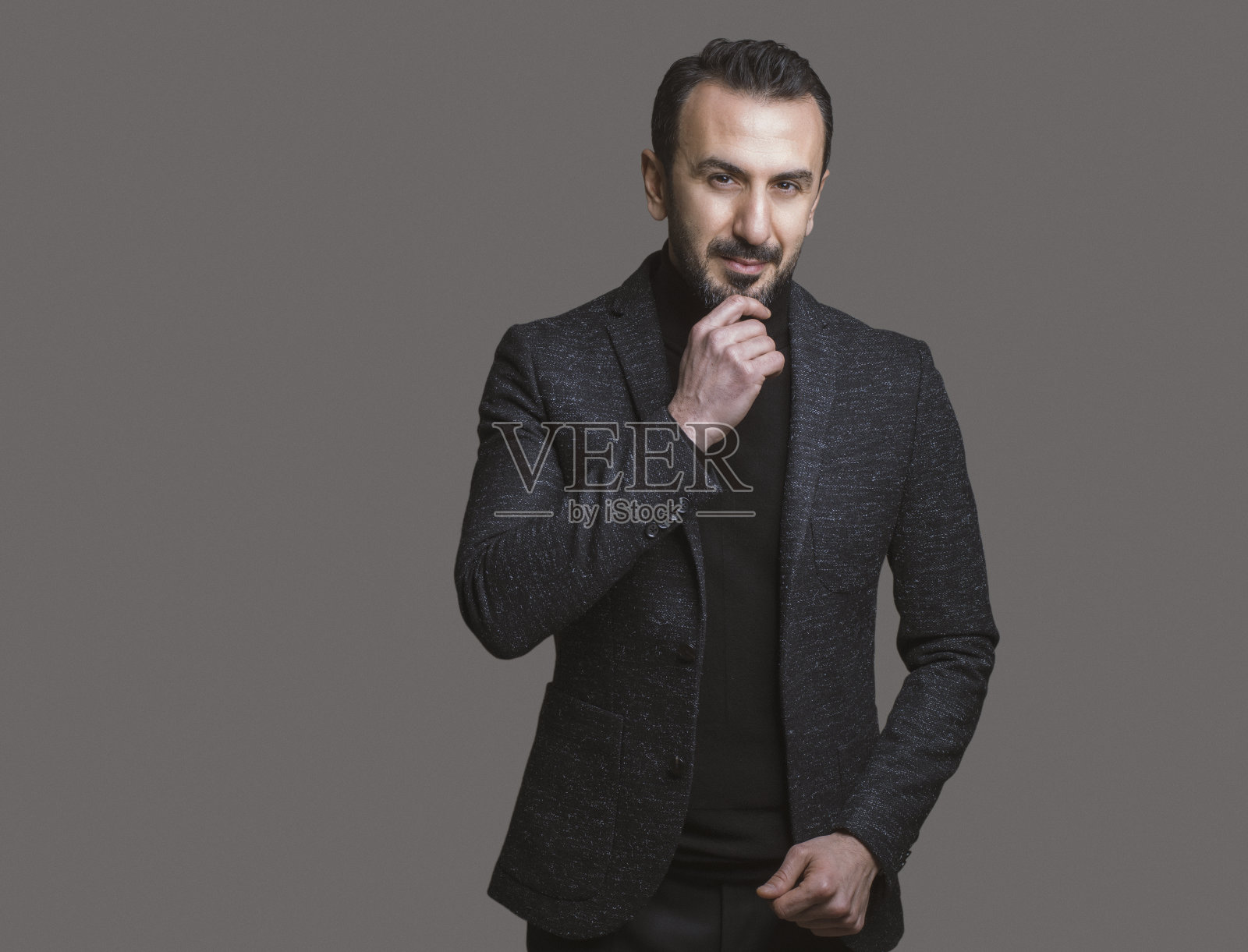 时尚的成熟男子摆姿势在灰色背景，工作室拍摄照片摄影图片