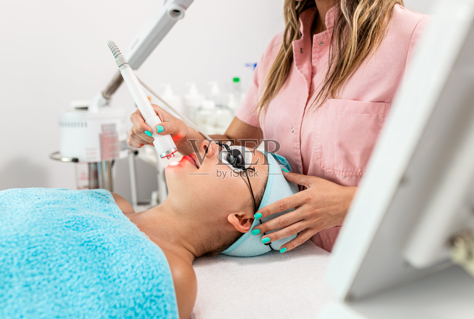 美容师在美容院为年轻女性进行面部治疗。照片摄影图片