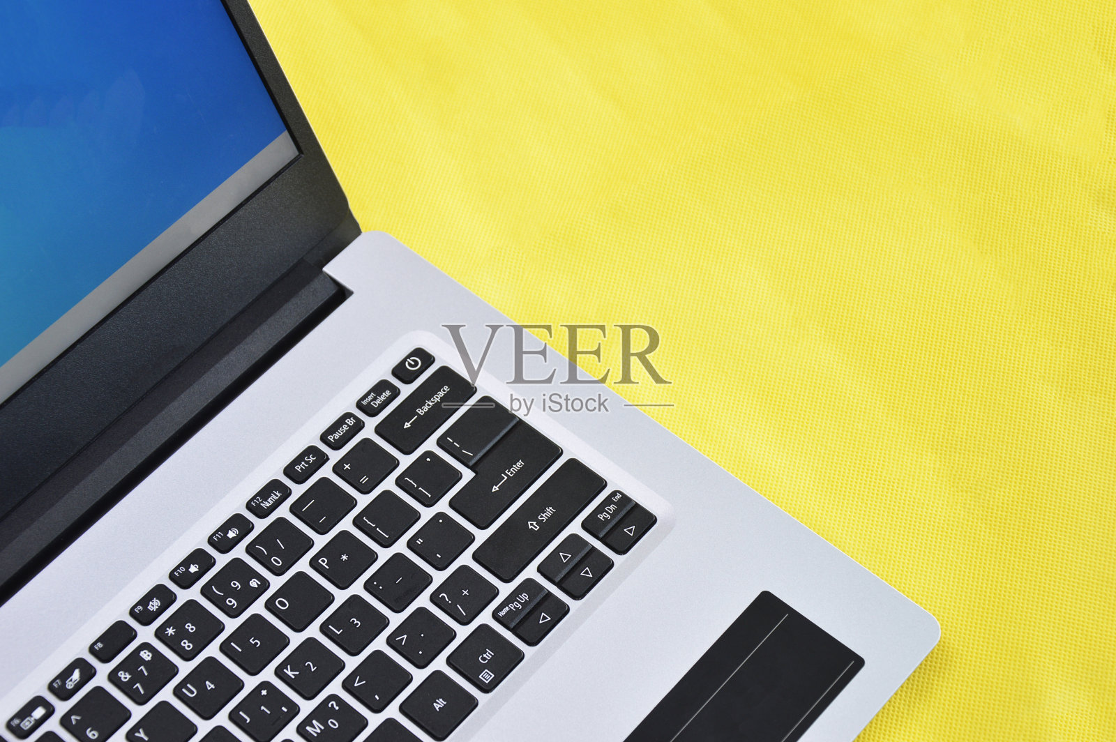 右上方的白色笔记本电脑在黄色背景照片摄影图片