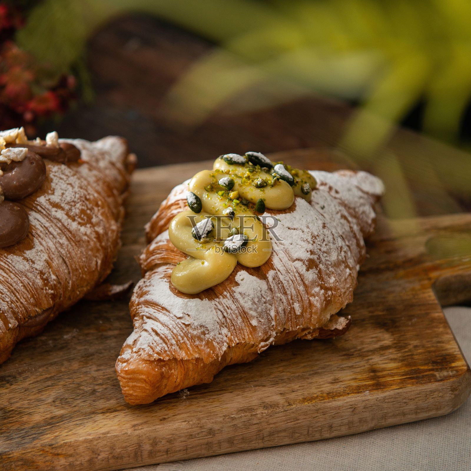 加了糖粉和开心果奶油的美味羊角面包的特写镜头照片摄影图片