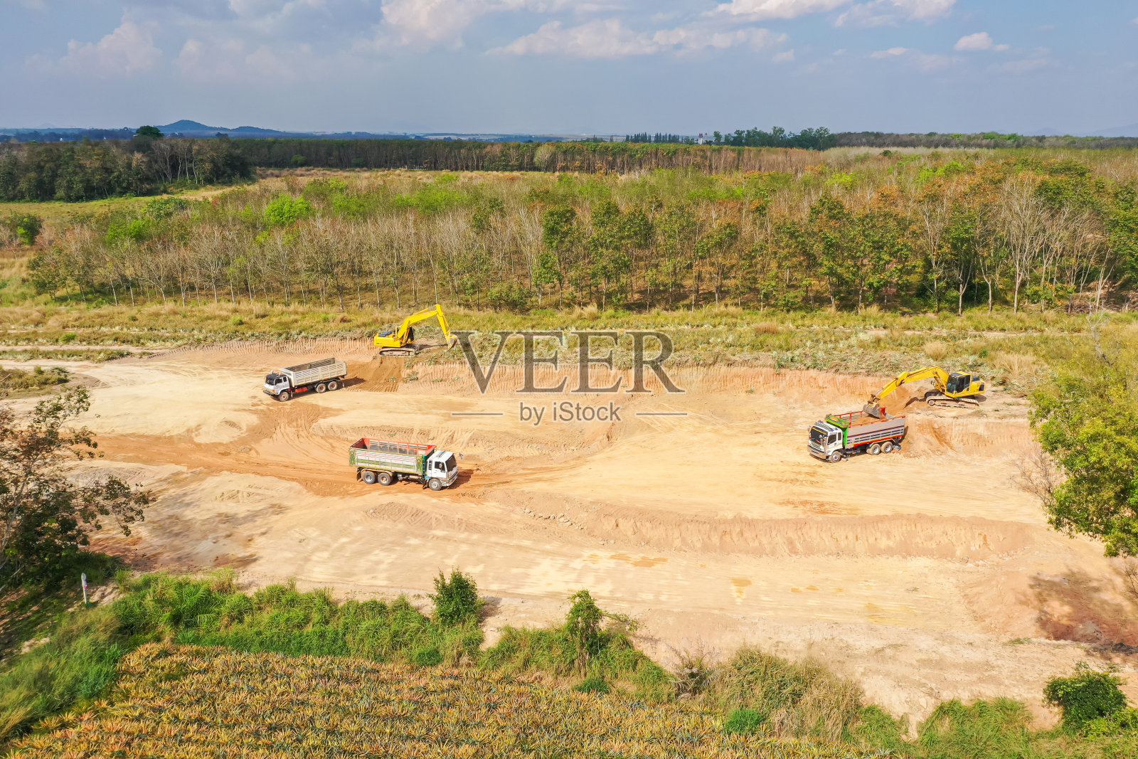 挖掘机在建筑工地的鸟瞰图。无人机拍摄建筑工地。重型设备正在给土地分级照片摄影图片